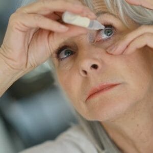 Woman putting in eye drops