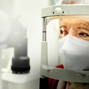 Senior woman wearing COVID mask gets eye exam